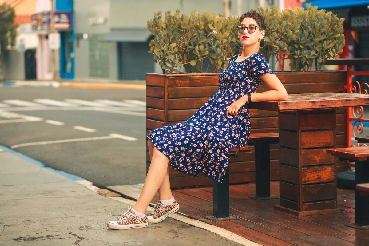 Woman in a floral sundress relaxing outdoors on a warm day