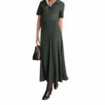Woman in a dark green ribbed knit polo dress with brown boots and handbag